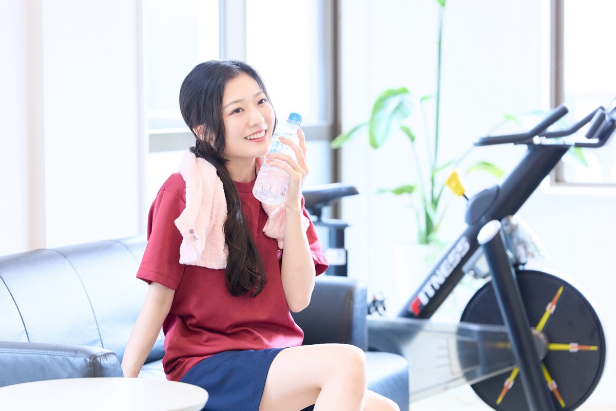 トレーニングの合間にソファで休みながら水分をとる様子